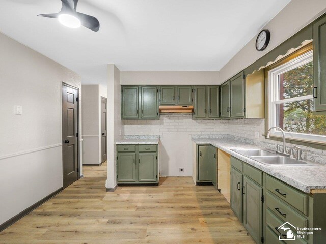 6405 Stillwater Ct, Erie, MI 48133 - kitchen with green cabinetry, a sink, backsplash, and light wood-style flooring