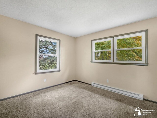 6405 Stillwater Ct, Erie, MI 48133 - spare room featuring a baseboard heating unit, plenty of natural light, carpet flooring, baseboards, and a textured ceiling