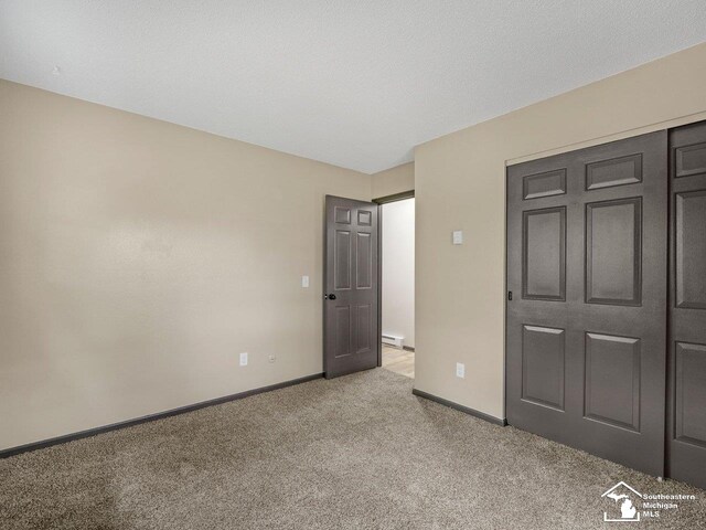 6405 Stillwater Ct, Erie, MI 48133 - unfurnished bedroom featuring light carpet, baseboards, and a baseboard radiator