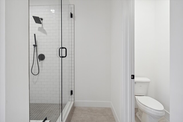 bathroom featuring an enclosed shower, tile patterned floors, and toilet