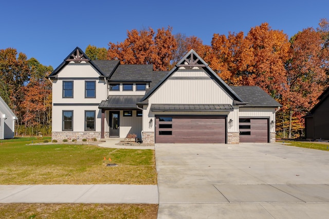 2680 Ashford Trl, Portage, MI 49024 - view of front of home with a standing seam roof, a garage, a front lawn, concrete driveway, and stone siding
