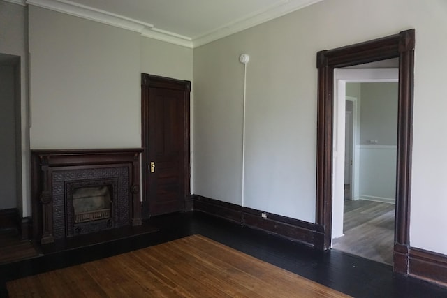 unfurnished living room featuring dark wood-type flooring and ornamental molding