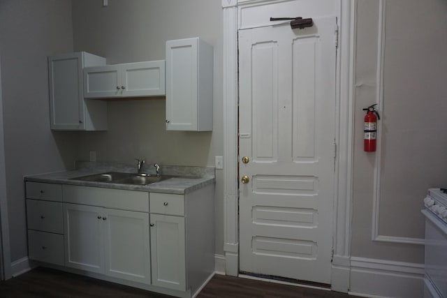 kitchen with white electric range oven, dark hardwood / wood-style flooring, white cabinets, and sink