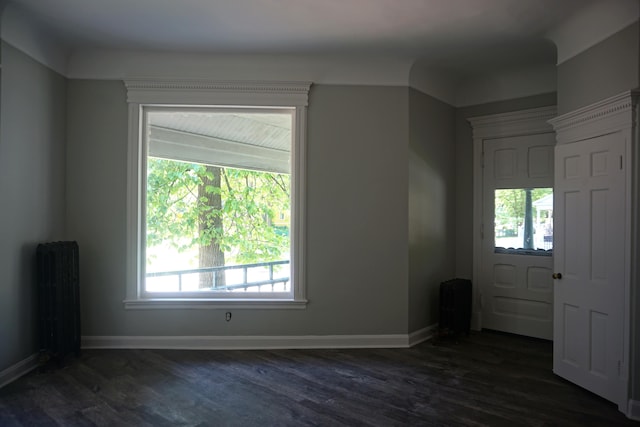 entryway with dark wood-type flooring and radiator heating unit