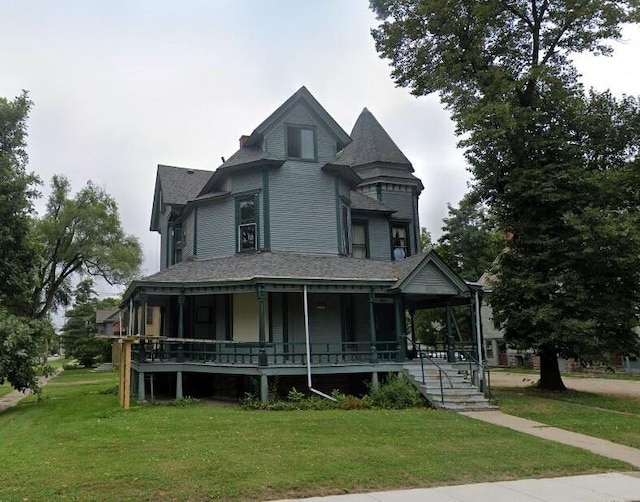 victorian house featuring covered porch and a front yard