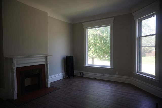 unfurnished living room with radiator and dark wood-type flooring