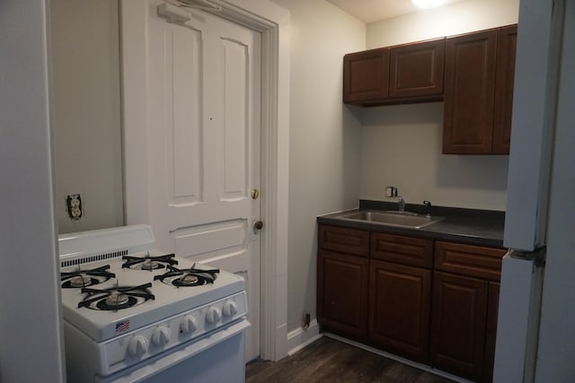 kitchen featuring dark hardwood / wood-style flooring, sink, dark brown cabinetry, and white appliances