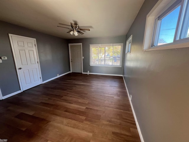 empty room with ceiling fan and dark wood-type flooring