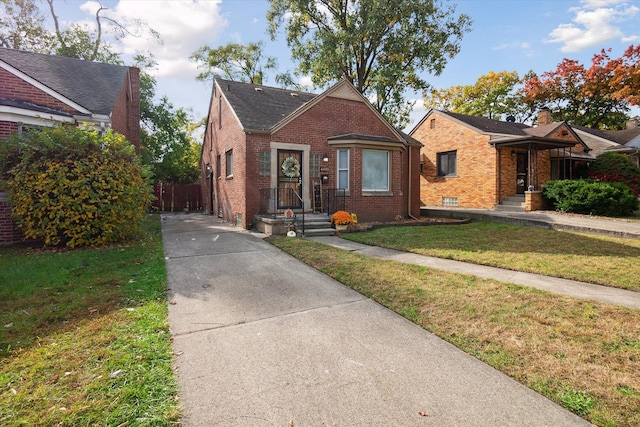 bungalow-style home with a front lawn