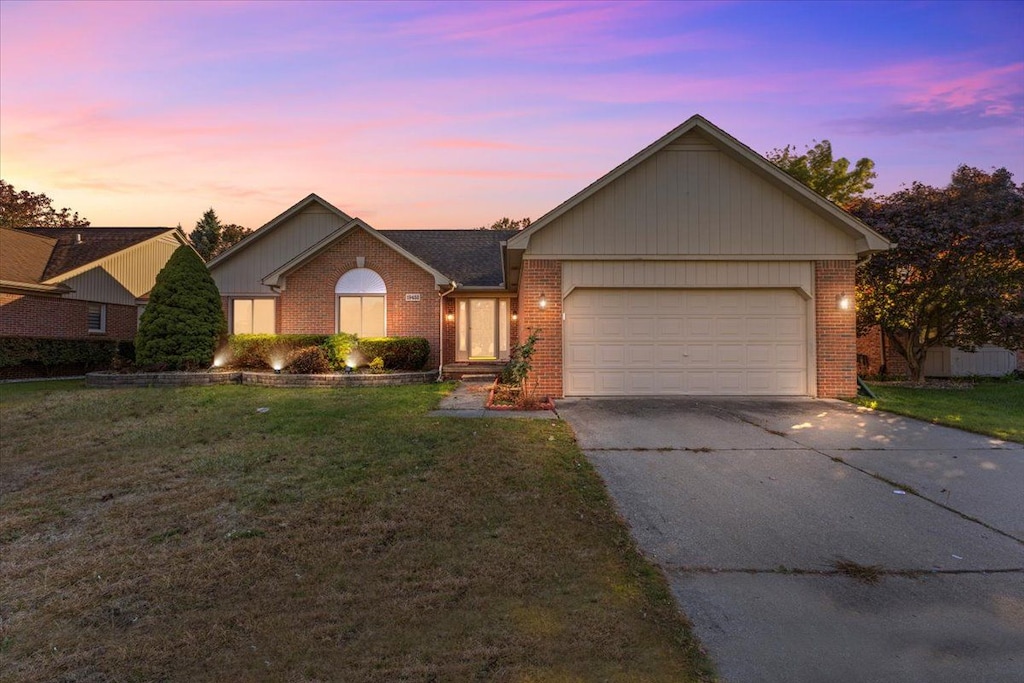 single story home featuring a yard and a garage