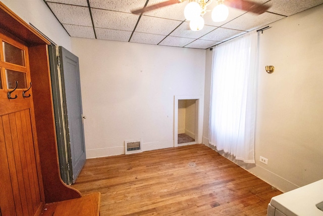 unfurnished room featuring hardwood / wood-style flooring, a drop ceiling, and ceiling fan