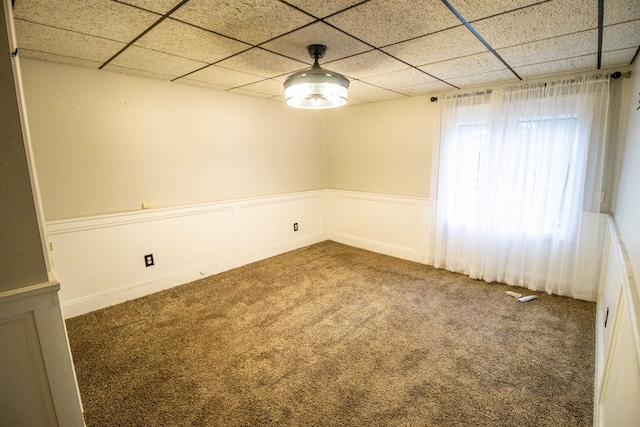 spare room featuring carpet flooring and a paneled ceiling