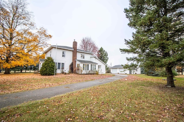 view of home's exterior with an outdoor structure, a garage, and a yard