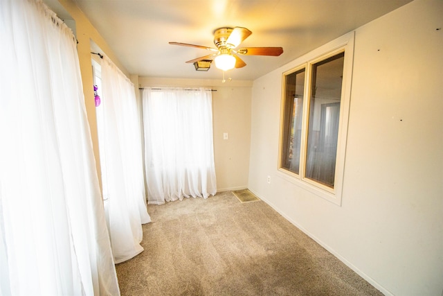 carpeted spare room with ceiling fan