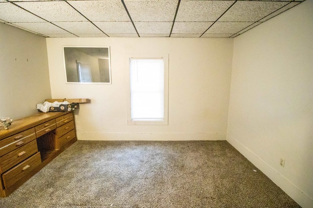 unfurnished room featuring carpet and a paneled ceiling