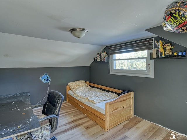 bedroom featuring hardwood / wood-style flooring and lofted ceiling