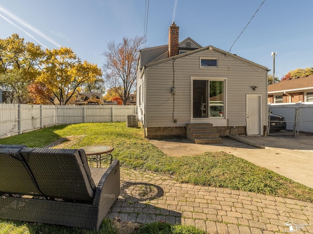 back of property with a yard, central AC unit, and a patio area