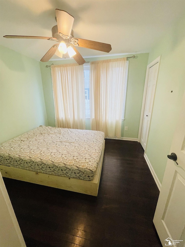 unfurnished bedroom featuring dark hardwood / wood-style floors and ceiling fan