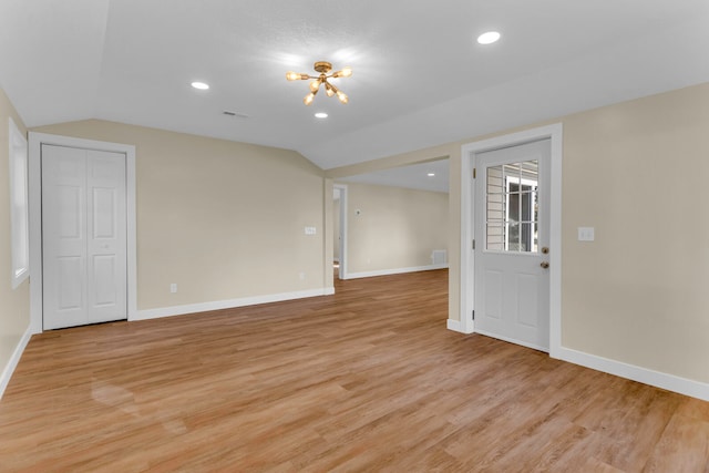 unfurnished room featuring light hardwood / wood-style floors and vaulted ceiling