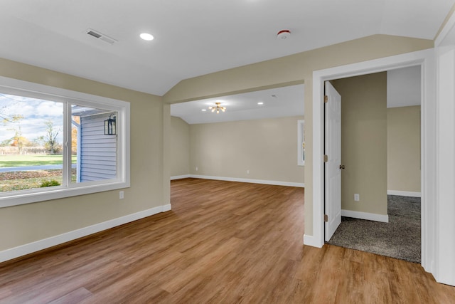 unfurnished room featuring light hardwood / wood-style floors and lofted ceiling