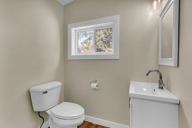 bathroom featuring vanity, wood-type flooring, and toilet