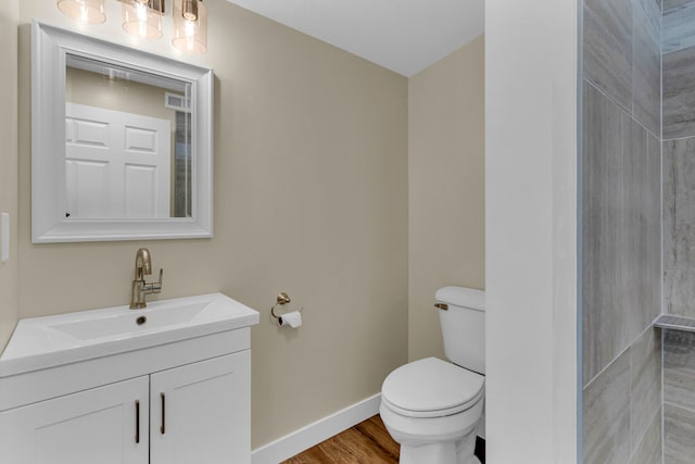 bathroom featuring vanity, wood-type flooring, and toilet