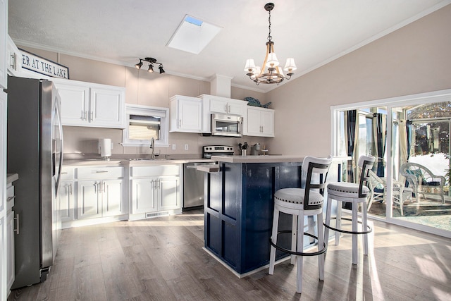 kitchen featuring white cabinetry, a center island, a healthy amount of sunlight, and appliances with stainless steel finishes