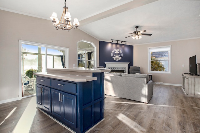 interior space with dark hardwood / wood-style floors, ornamental molding, ceiling fan with notable chandelier, and track lighting