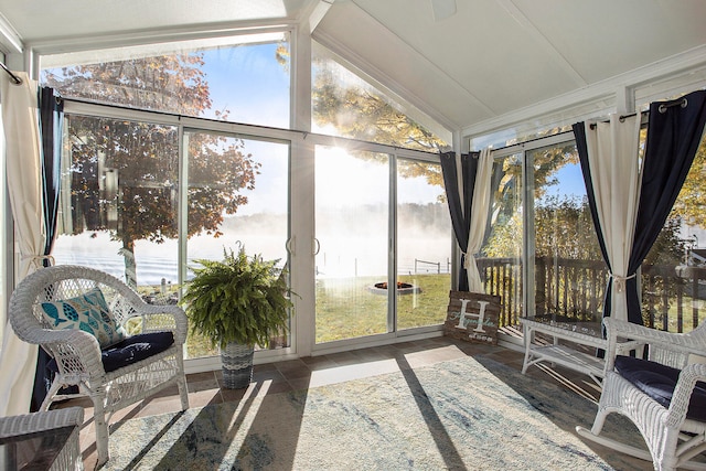 sunroom featuring a water view, vaulted ceiling, and a wealth of natural light