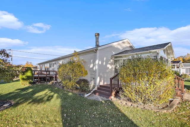 rear view of property featuring a wooden deck and a yard