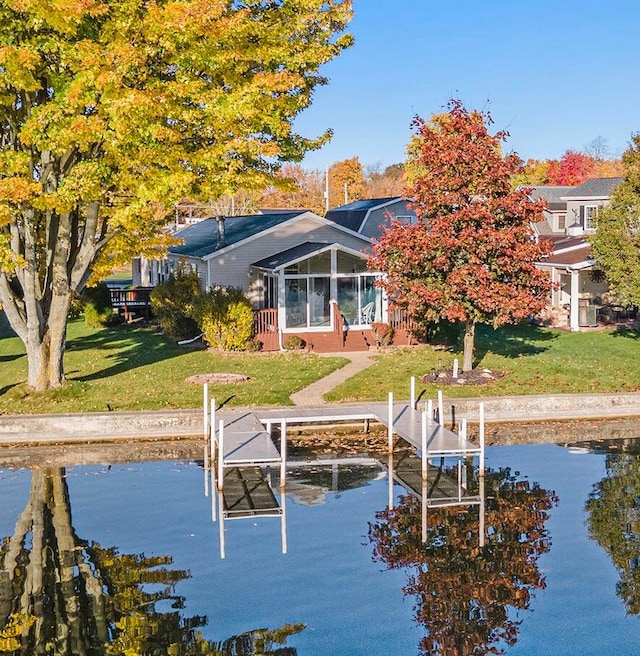 view of dock with a water view and a yard