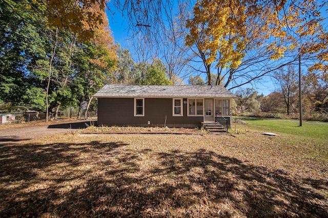 view of front of house featuring a sunroom and a front lawn