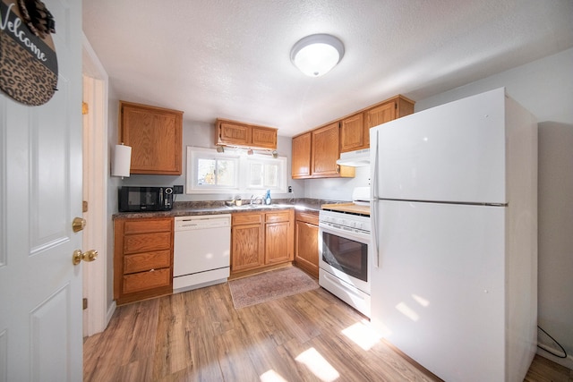 kitchen featuring white appliances, a textured ceiling, and light hardwood / wood-style flooring