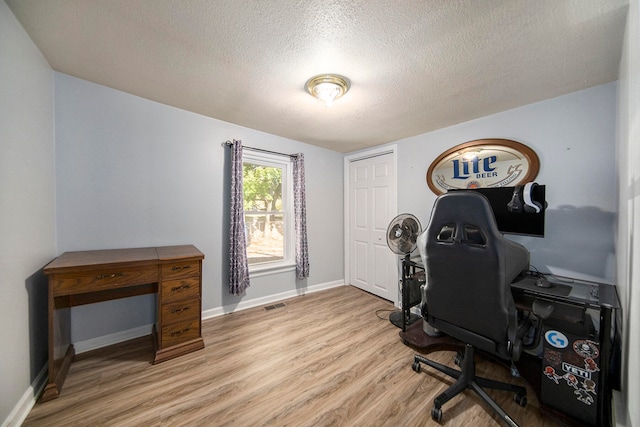 office space featuring a textured ceiling and light hardwood / wood-style floors