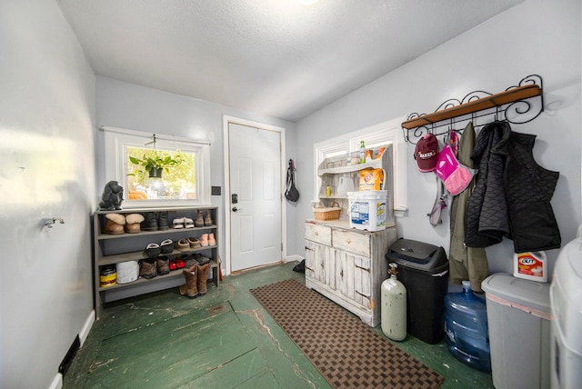 mudroom featuring a textured ceiling and lofted ceiling