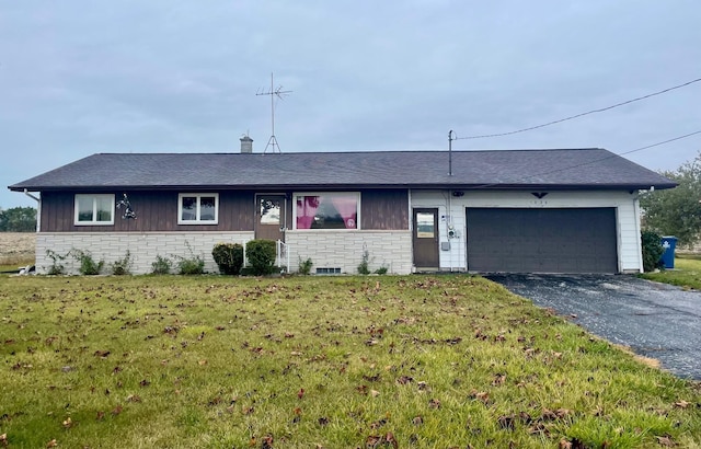 ranch-style house featuring a front lawn and a garage