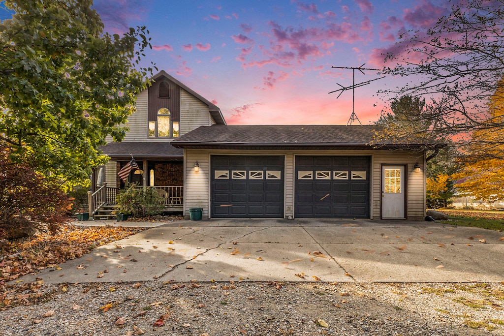 view of property with a porch and a garage