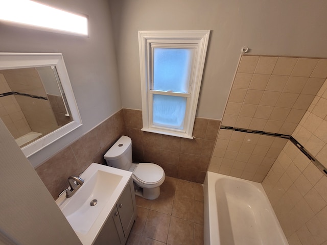 bathroom with tile patterned flooring, vanity, toilet, and tile walls