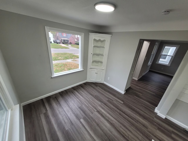 unfurnished dining area featuring dark wood-type flooring