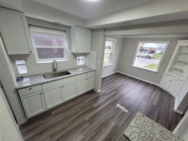 kitchen with decorative backsplash, dark hardwood / wood-style flooring, white cabinetry, and sink