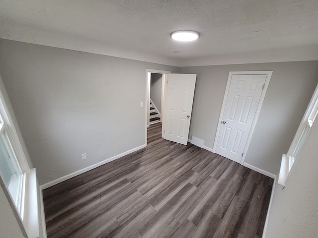 unfurnished bedroom with hardwood / wood-style floors and a closet