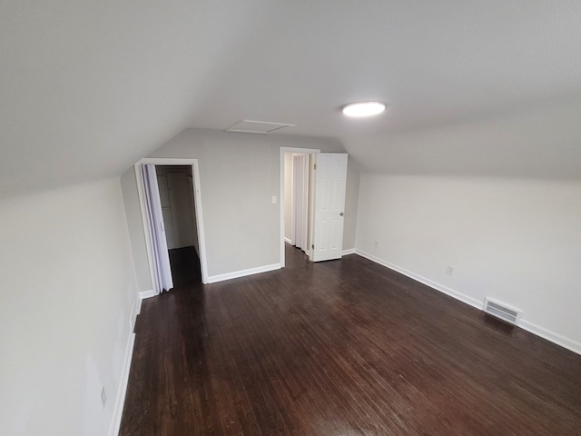 bonus room with lofted ceiling and dark wood-type flooring