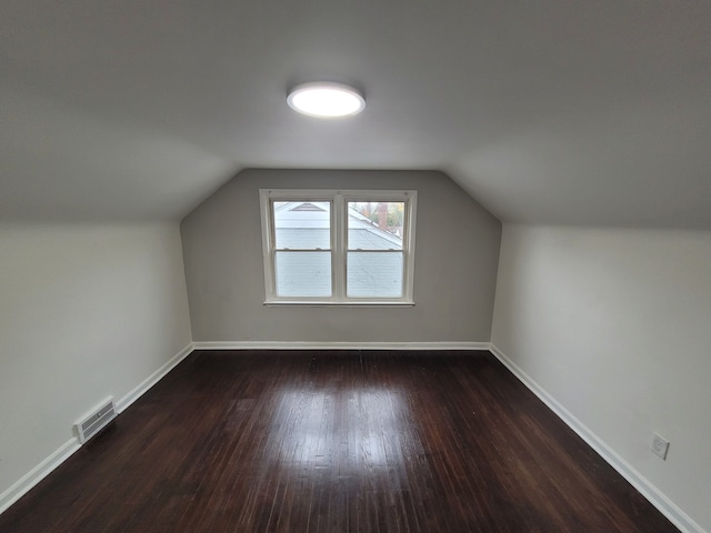 additional living space with dark hardwood / wood-style floors and lofted ceiling