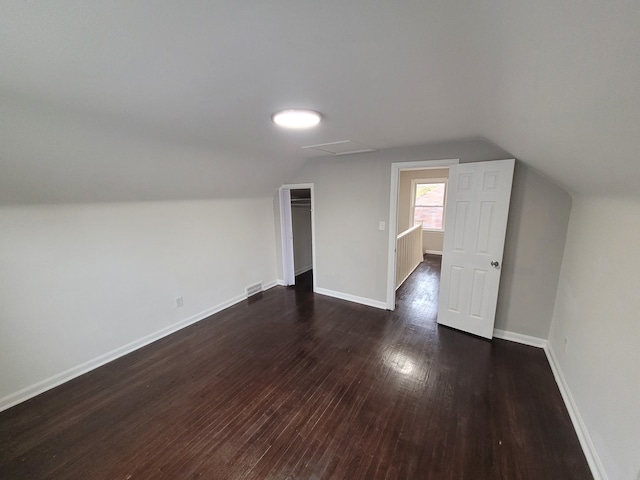 bonus room with dark hardwood / wood-style flooring and vaulted ceiling