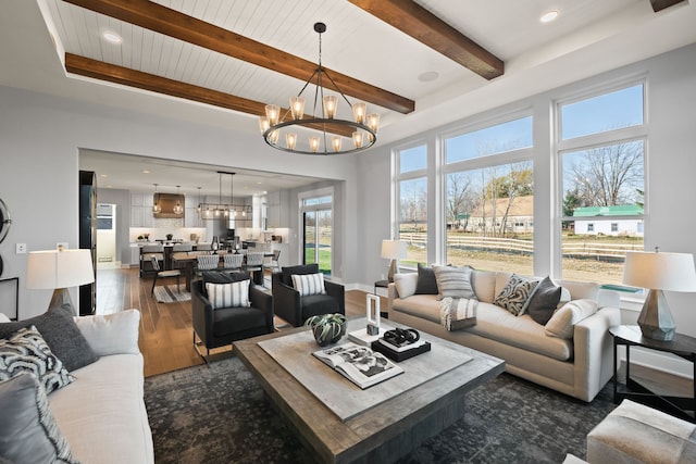 living room with beamed ceiling, dark hardwood / wood-style flooring, and a chandelier