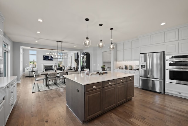 kitchen featuring dark brown cabinetry, dark wood-type flooring, white cabinets, and stainless steel appliances