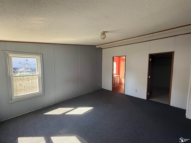 carpeted spare room with a textured ceiling and ornamental molding