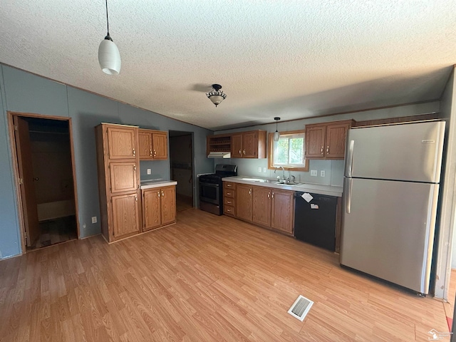 kitchen with pendant lighting, light wood-type flooring, a textured ceiling, and black appliances