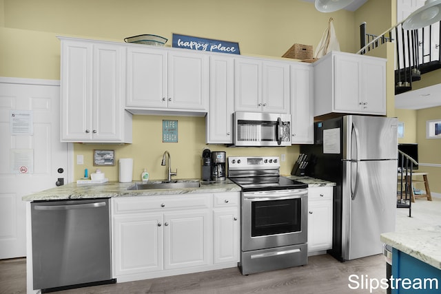 kitchen featuring white cabinetry, sink, hardwood / wood-style floors, and appliances with stainless steel finishes