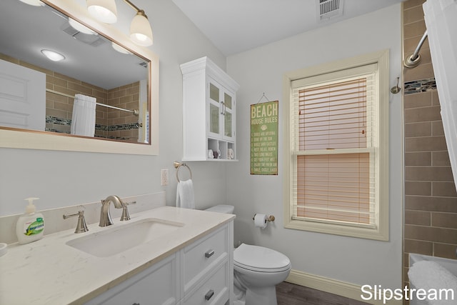 bathroom with a shower with curtain, vanity, wood-type flooring, and toilet